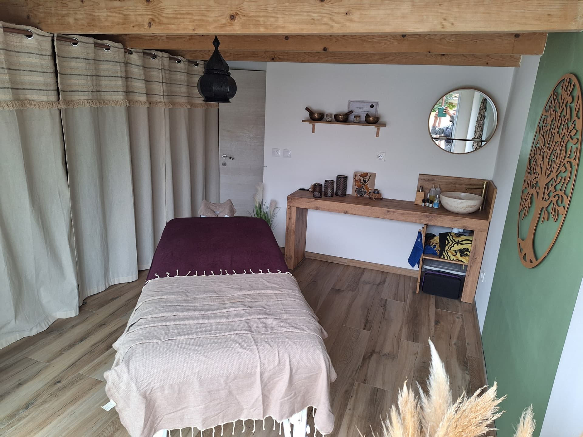Espace de massage calme et chaleureux avec table de massage, bois clair et décoration naturelle